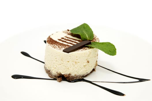 creamy dessert is decorated with mint on a white plate