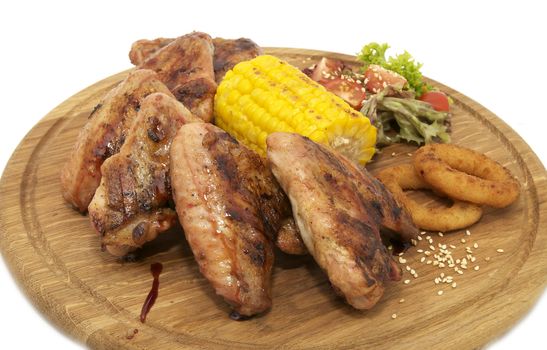 chicken wings with sweet corn on a wooden plate
