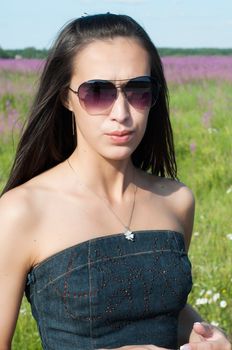 Outdoor shot of beautiful brunette woman with long hair in sunglases