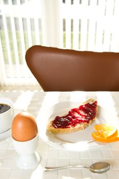 Egg, bread with jam for breakfast. Sunny morning