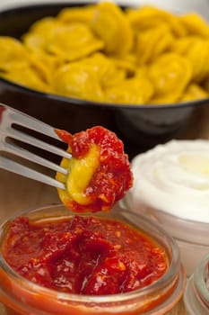 Yellow dumplings with catchup on a plate closeup