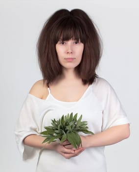 The young beautiful woman with the fresh sage, the concept of healthy food