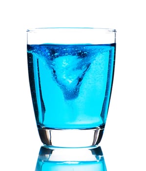 A glass with light blue water on white background as a studio shot