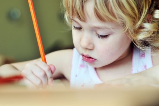 serious little girl drawing in soft selective focus 