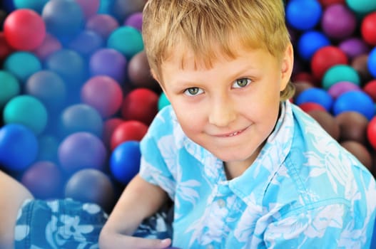 boy having fun in pile of balls in the amusement park