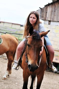 teen longhaired girl sitting on the horse