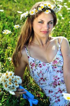 beauty spring girl with garland from daisies