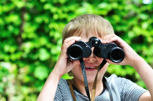 Boy looking through binocular in selective focus