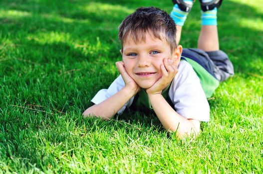  little boy laying on the sunny meadow 