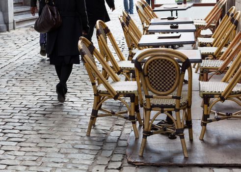 Row of empty restaurant tables in cobbled street in Brussels