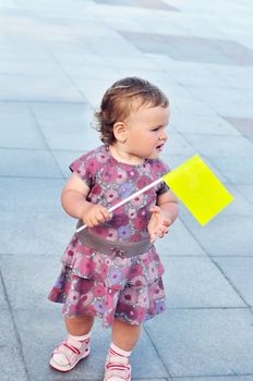 funny baby girl holding yellow flag