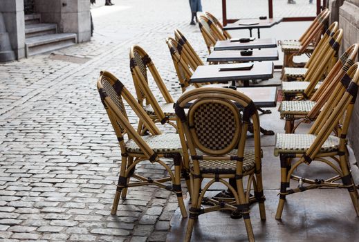Row of empty restaurant tables in cobbled street in Brussels