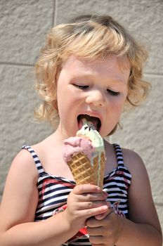 little blonde girl eating big ice cream cone 