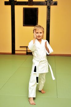  	little boy has just got his first white belt in aikido