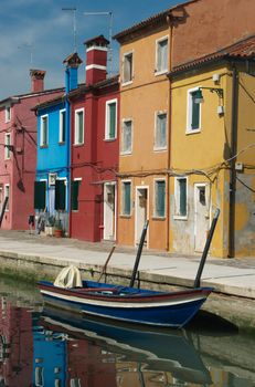 Colorful houses and the boat on the island of Burano near Venice