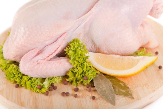 Close-up shot of fresh raw chicken with condiments and lemon 