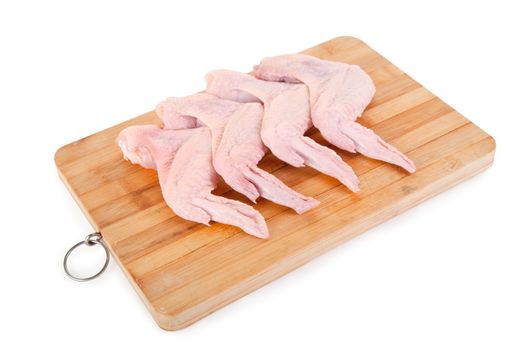 Raw chicken wings on wooden board, isolated on white background, clipping path included 