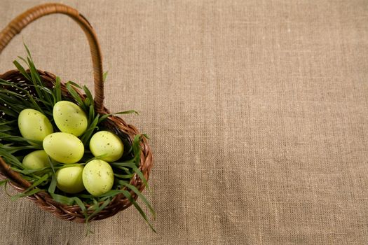 Basket with Easter eggs in grass, selective focus, lot of copy-space 