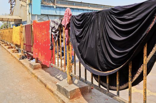 Mahalaxmi Station, Mumbai, India, colors of family washing out to dry on railway railings