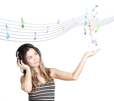 Young attractive woman listing to music with headphones , keeps sounds at hand, the concept