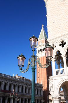 Famous pink venetian street lamp against St. Mark Befry