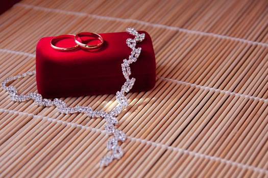 two wedding rings of gold on the red box on the table