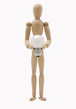 Wooden mannequin holding an energy efficient lightbulb over white background