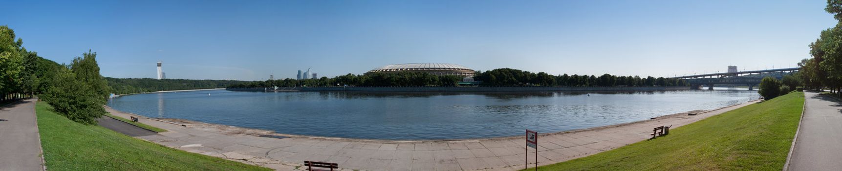 panorama of the river bank moscow with the grass and some builings