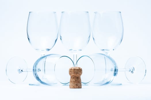 glass wine stand symmetrically with cork of bottle on white