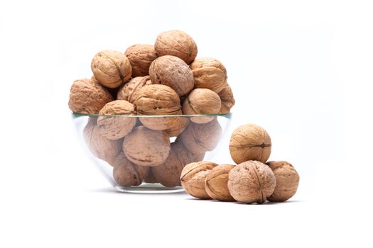 Walnuts are a lie in a glass bowl isolated on a white background