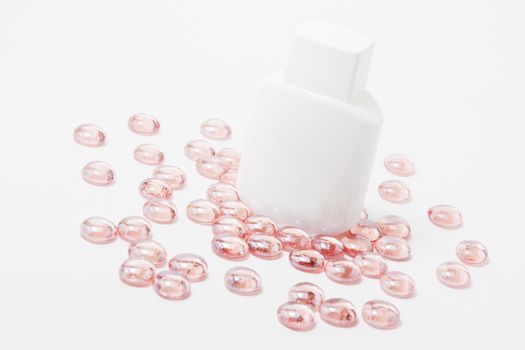 white container for cosmetics on pink glass stones on white