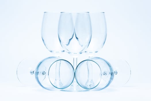 Empty wine glasses stand and lie symmetrically on a white background