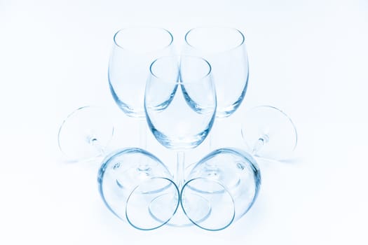 Empty wine glasses stand symmetrically on a white background