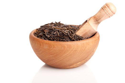 wild rice in the wooden bowl with spoon, on a white background