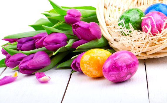 Easter eggs and bouquet tulips, on white wooden