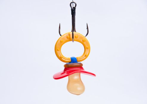 infant pacifier hangs on a triple fish hook. not isolated