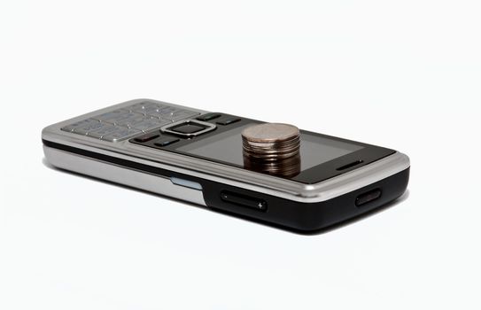 cell phone and a column of coins. isolated on white