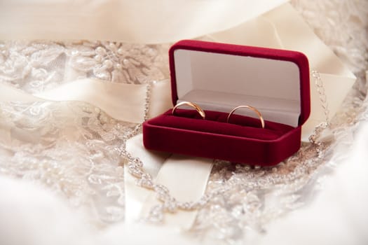 two wedding rings of gold in the red box on the wedding dress