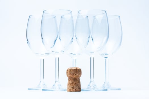 glass wine stand symmetrically with cork of bottle on white