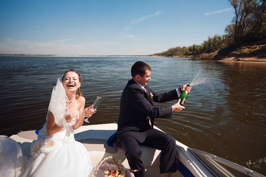 bride and groom with champagne on the boat