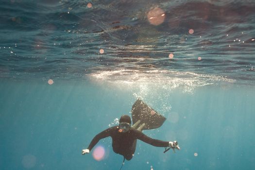 a portrait of freediver in water with camera