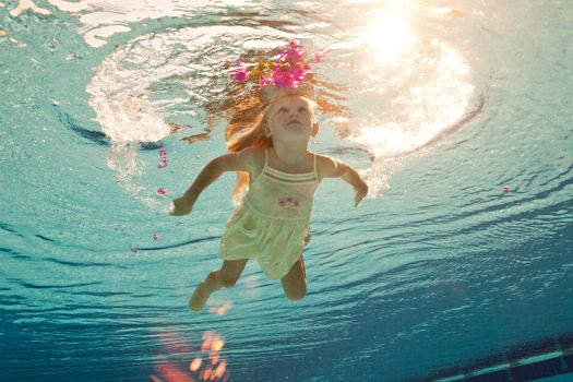 girl in the swimming-pool under water with a flower