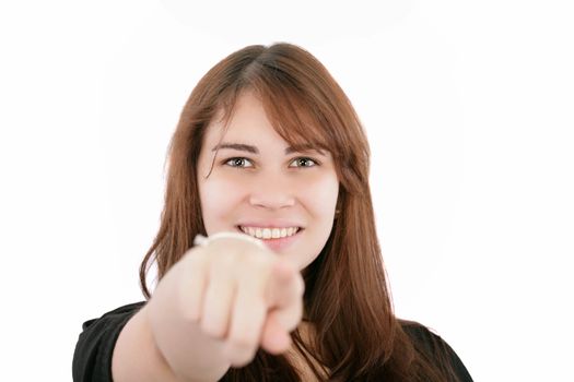 Portrait of a young smiling businesswoman pointing at you. Isolated on white. Focus on woman