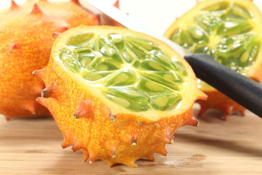 fresh sliced orange Kiwano on a wooden board