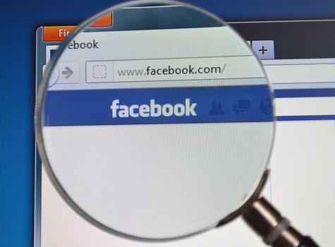 Search Facebook website with magnifying glass