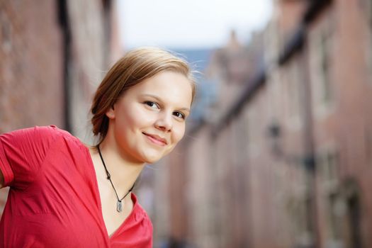 Happy young woman photographed in a city street