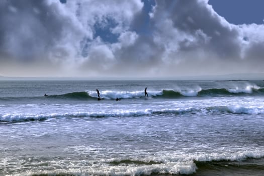 beautiful clean atlantic ocean with surfers catching the waves during a storm on Irelands coast