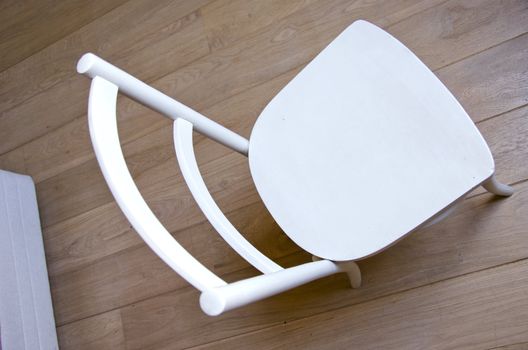chair object retro vintage painted white standing on wooden oak floor.