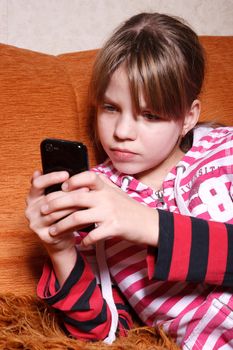 a very serious girl playing games on their touch screen phone