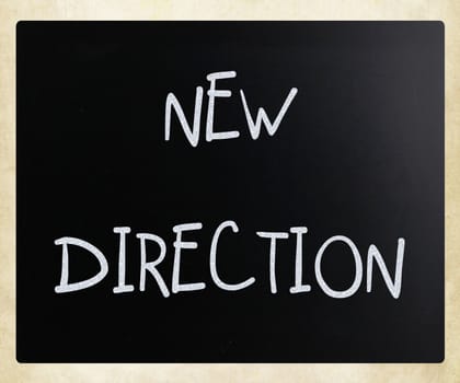 "New direction" handwritten with white chalk on a blackboard